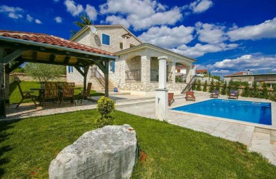 Una bella villa in pietra con ampio giardino e piscina