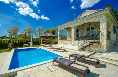 Eine schöne Villa aus Stein mit einem großen Garten und Swimmingpool